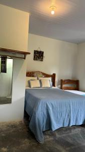 a bedroom with a large bed with a blue blanket at Pousada paraíso pedra do Rodeadouro in Bonito