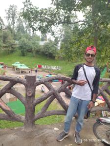 a man standing next to a wooden fence at Muslim friendly guest house in Sialkot