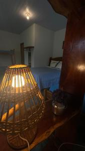 a room with a bed and a bird cage on a table at Pousada paraíso pedra do Rodeadouro in Bonito