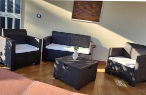 uma sala de estar com cadeiras de vime e uma mesa em sabbiadoro sul mare avola em Avola