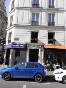 a blue car parked in front of a building at Marie et Igor in Paris