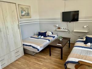una piccola stanza con due letti e una tv di Feniks apartman a Apatin