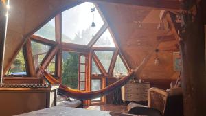 a room with a hammock in a tree house at Domo Conguillio, Salto Truful Truful in Melipeuco