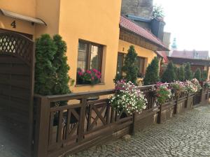 a fence with flowers in front of a building at Spadzista 4 in Kłodzko