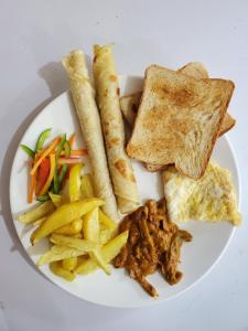 a plate of food with toast and french fries at Kizumba House in Arusha
