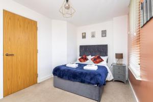Schlafzimmer mit einem Bett und einer Holztür in der Unterkunft Wakefield City Centre - Parking, Self Check-in, Wi-Fi, Workspace, Balcony - Families, Contractors, Long Stays - Alt-Stay in Wakefield