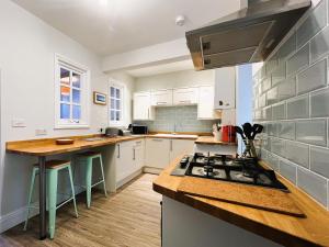 Orchard Cottage في فنتنور: مطبخ بخزائن بيضاء وفرن موقد