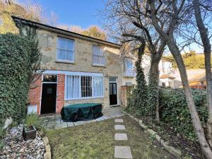 Orchard Cottage في فنتنور: منزل من الطوب مع طاولة خضراء في الفناء