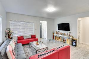 a living room with a red couch and a flat screen tv at Charming Auburn Home 15 Mi to Downtown Tacoma! in Auburn