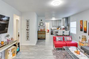 ein Wohnzimmer mit einem roten Sofa und einer Küche in der Unterkunft Charming Auburn Home 15 Mi to Downtown Tacoma! in Auburn