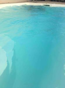 a large swimming pool with blue water in it at Villa charmante avec piscine à Saint-Gilles in Saint-Gilles