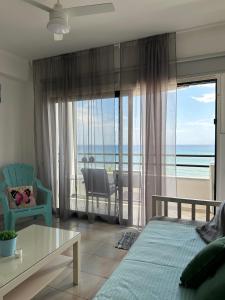 a bedroom with a bed and a view of the ocean at Krasas Beach in Larnaka