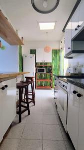 eine Küche mit weißen Geräten und einem Tisch darin in der Unterkunft Casa Canaria shared house in El Médano