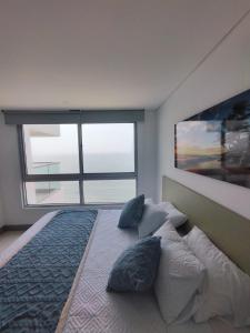 卡塔赫納的住宿－Palmetto Beach Cartagena vista de frente al mar，卧室设有一张大床,卧室设有大窗户