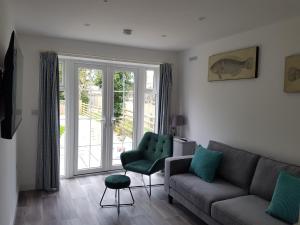 a living room with a couch and a chair and a window at Gorgeous Cottage by the sea sleeps 10 5 bed 4 bath in Heacham