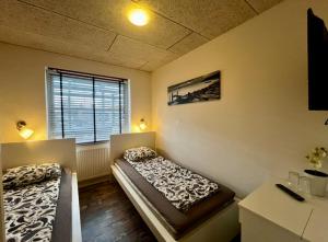 two beds in a room with a window at Barneys Rooms in Hundige