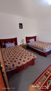 two beds sitting in a room with at Petra Magic Guest House in Wadi Musa