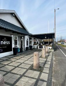 een winkel met pilaren voor een gebouw bij Barneys Rooms in Hundige