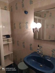 uma casa de banho com um lavatório azul e um espelho. em Piso primera línea de playa em Chipiona