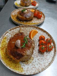 drei Teller mit Fleisch und Gemüse darauf. in der Unterkunft Quinta do Caminho, AL in Valença