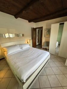 una camera con un grande letto bianco di -Ortaflats- Appartamento l'Isola a Orta San Giulio