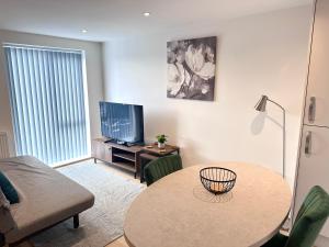 a living room with a table and a tv at All Inn Apartments in Staveley