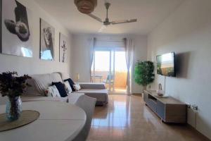 a living room with a couch and a tv at ¡Espectacular apto con vistas al mar con Wifi! in Comarruga