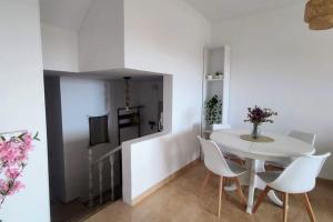 a white dining room with a white table and chairs at ¡Espectacular apto con vistas al mar con Wifi! in Comarruga