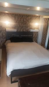 1 dormitorio con cama blanca y pared en Maison trois chambres, en Schwändi