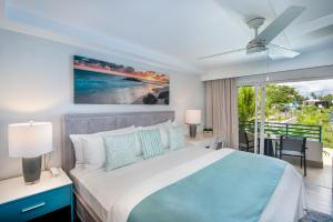 a bedroom with a bed and a view of the ocean at Blue Haven Holiday Apartments in Christ Church