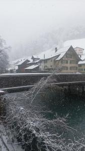 a snow covered town with houses and buildings at Maison trois chambres in Schwändi