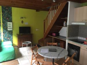 una cucina e una sala da pranzo con tavolo e sedie di La maisonnette a Les Andelys Altre 12 foto
