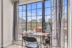 Una oficina con un escritorio y sillas frente a una gran ventana. en Downtown Columbia Apartment, en Columbia
