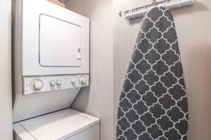 a bathroom with a washing machine and a shower curtain at Downtown Columbia Apartment in Columbia
