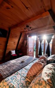 ein Schlafzimmer mit einem Bett in einem Zimmer mit Holzdecken in der Unterkunft Casa Jardin De Julia in San Juan Obispo