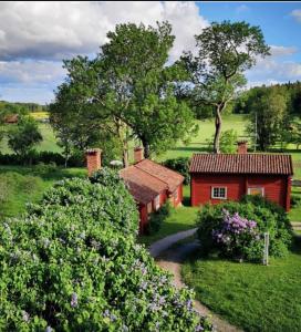 una casa roja en medio de un campo en Heritage-listed country cottages en Eskilstuna