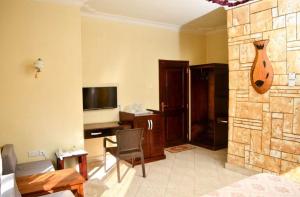 uma sala de estar com um sofá, uma secretária e uma televisão em Country lake resort Garuga em Wakiso