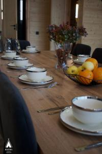 a long wooden table with plates and bowls of fruit at Rauda home in Uralʼsk