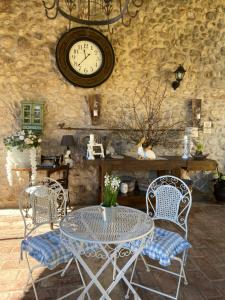 モンツァンバーノにあるGallo delle Pille country houseのテーブルと椅子(壁に時計付)
