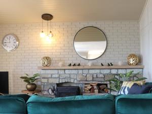 a living room with a blue couch and a fireplace at Sandpipers - Pet friendly in Ventnor