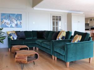 uma sala de estar com um sofá verde e duas cadeiras em Sandpipers - Pet friendly em Ventnor
