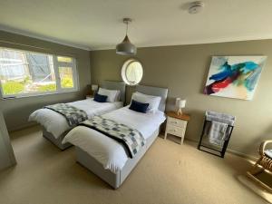 a bedroom with two beds and a window at Sandpipers - Pet friendly in Ventnor