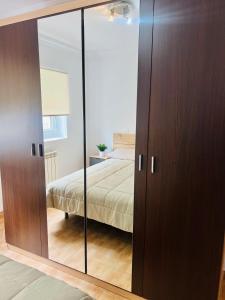a bedroom with a mirrored closet with a bed in it at Apartamento en Santander in Santander