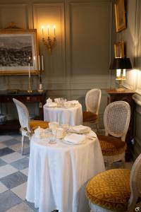 una sala da pranzo con due tavoli con tovaglie bianche di Manoir des Basses Rivières a Rochecorbon