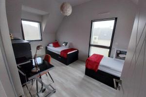 Habitación pequeña con 2 camas, escritorio y lámpara. en Beautiful new modern house, en Baden