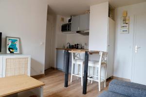 een kleine keuken met een tafel in een klein appartement bij Renovated apartment - near the beach in Ouistreham