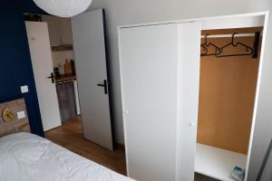 een slaapkamer met een witte kast en een bed bij Renovated apartment - near the beach in Ouistreham