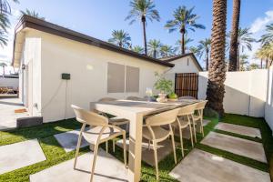 a patio with a table and chairs on the grass at Roma by AvantStay Stylish Oasis w Private Pool in Phoenix