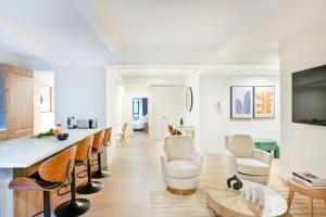 a large living room with a bar and chairs at 52-3DE Newly renovated 2BR BTH Midtown East in New York