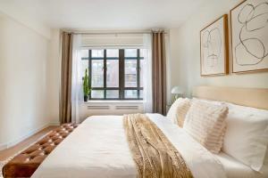 - une chambre avec un grand lit blanc et une fenêtre dans l'établissement 52-3DE Newly renovated 2BR BTH Midtown East, à New York
